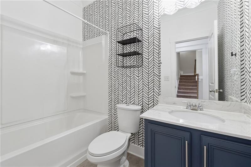 108 Madison Street Canton, GA 30115 - Photo 4 of 43 a bathroom with a granite countertop toilet sink and mirror