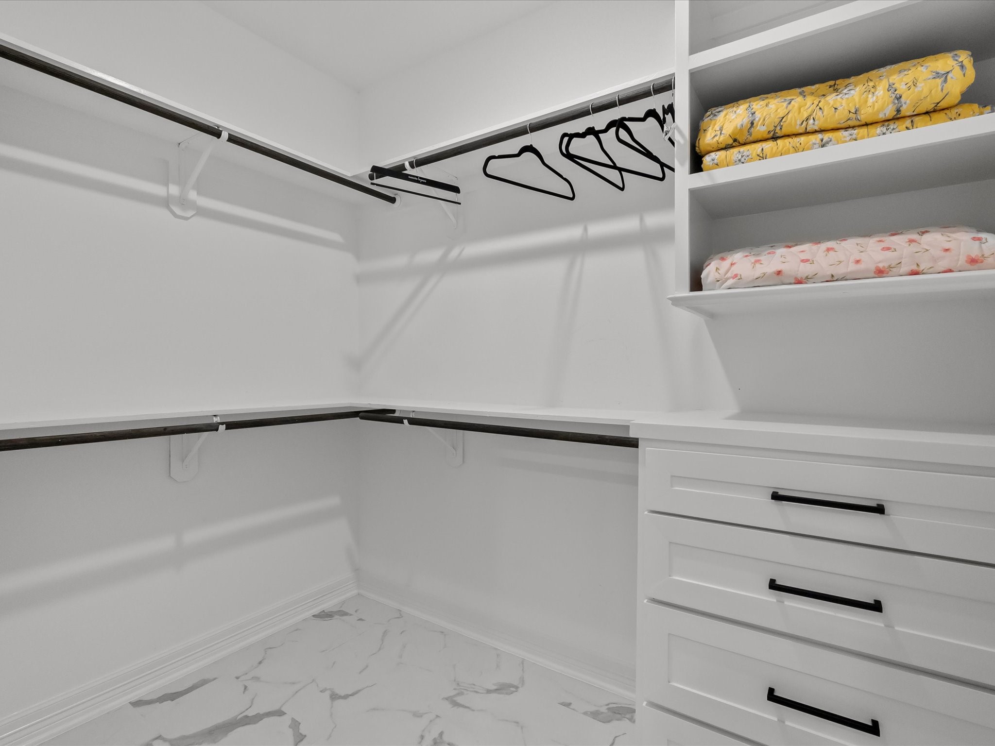 1018 Seashell Drive Surfside Beach, TX 77541 - Photo 42 of 49 This is a spacious walk-in closet featuring white shelving and drawers, ample hanging space, and a tiled floor. Perfect for organizing clothes and accessories.