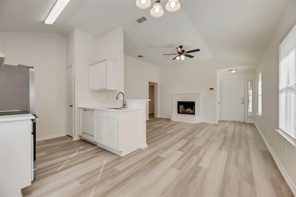 1048 Port Sullivan Drive Little Elm, TX 75068 - Photo 6 of 19 a view of a kitchen with wooden floor and a fireplace