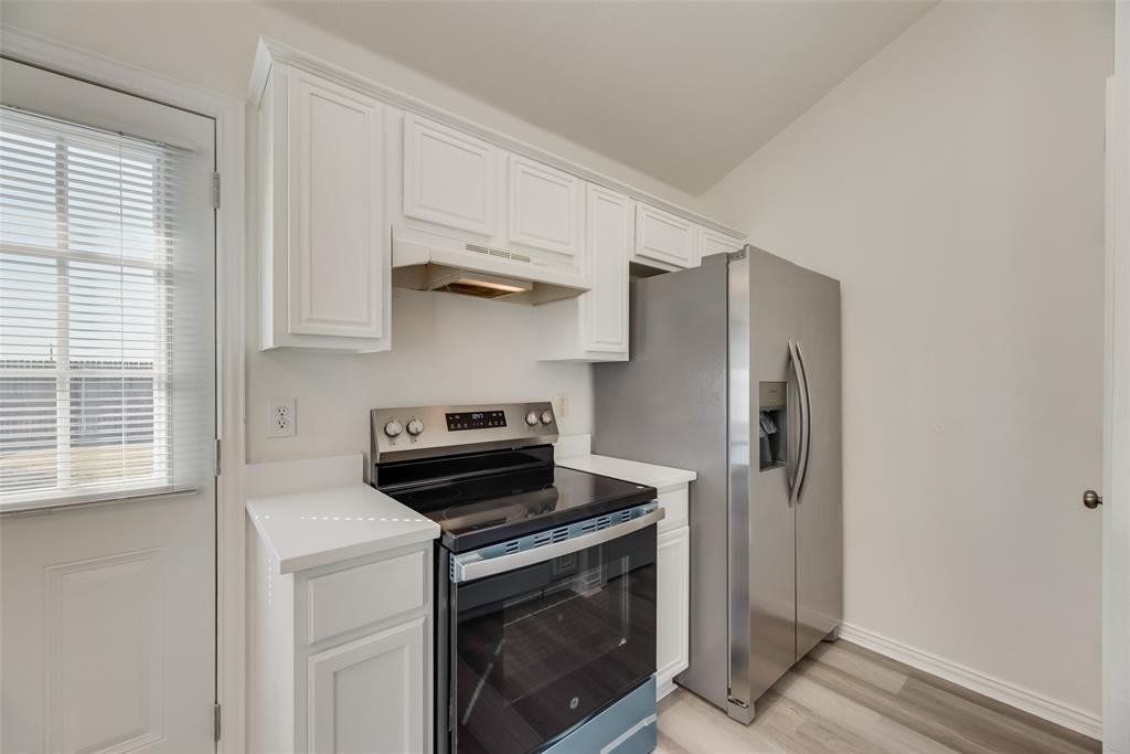 1048 Port Sullivan Drive Little Elm, TX 75068 - Photo 7 of 19 a kitchen with stainless steel appliances a stove a microwave and a refrigerator