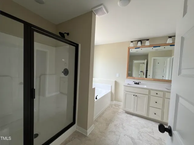 a bathroom with a double vanity sink mirror and shower