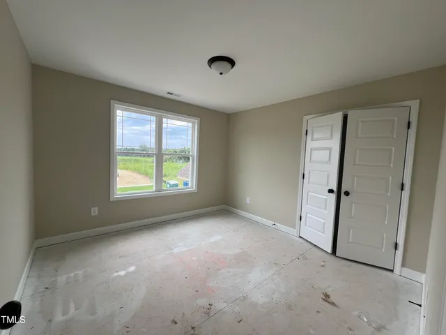 an empty room with windows and closet