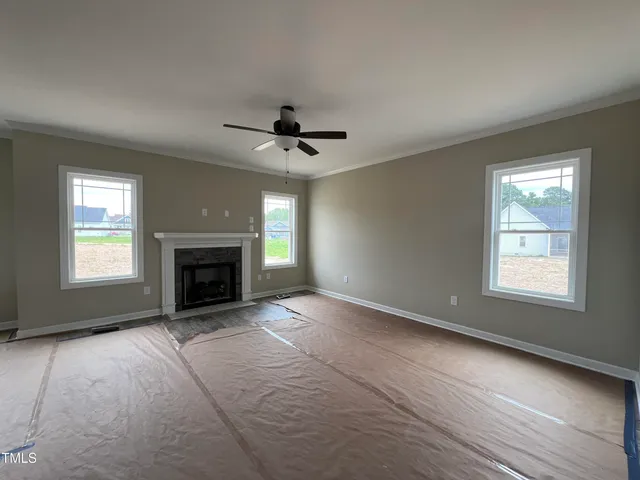 an empty room with windows and fireplace
