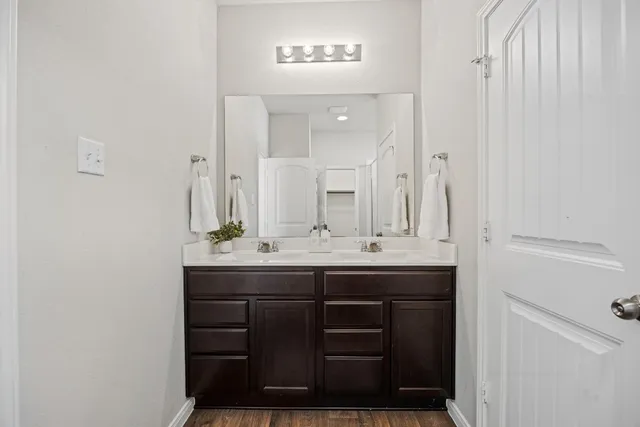 a bathroom with double sink and a mirror