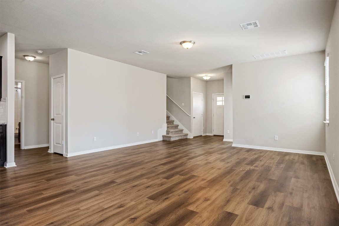110 Lullaby Drive Georgetown, TX 78626 - Photo 5 of 39 a view of an empty room with wooden floor and a ceiling fan