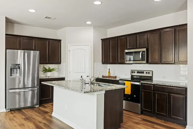 a kitchen with stainless steel appliances wooden cabinets and granite counter tops