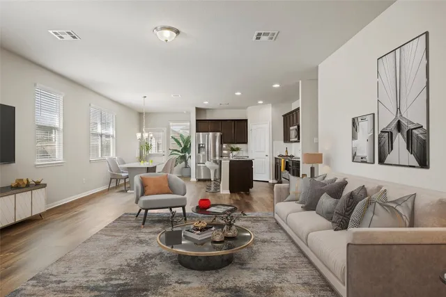 a living room with furniture kitchen view and a window