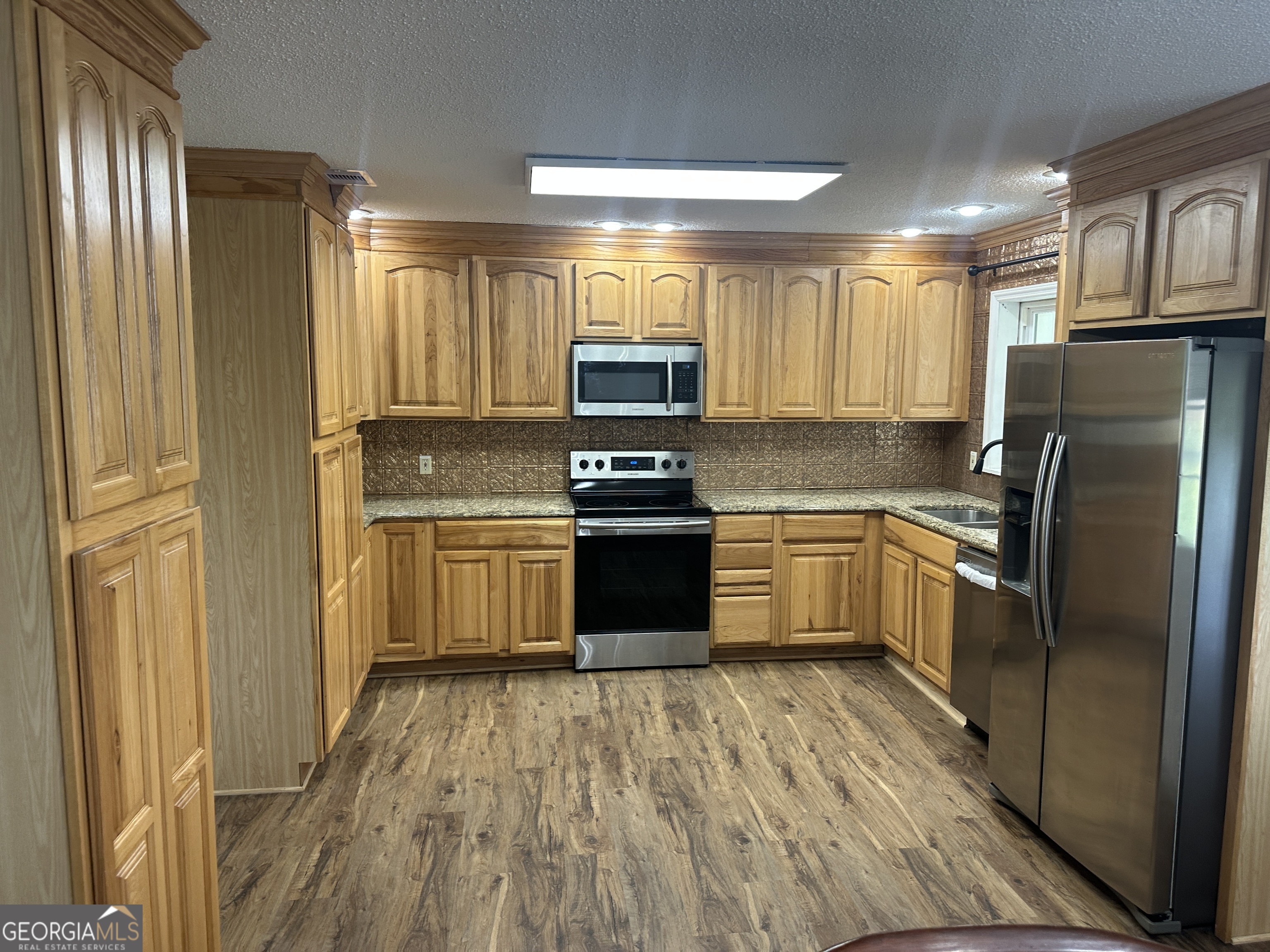 509 Whitehill Road Sylvania, GA 30467 - Photo 8 of 14 a kitchen with a refrigerator a stove top oven and cabinets