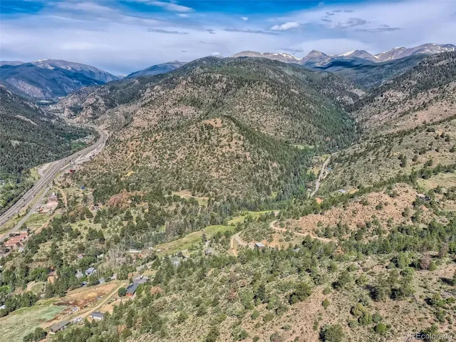 a view of a dry yard with mountains in the background