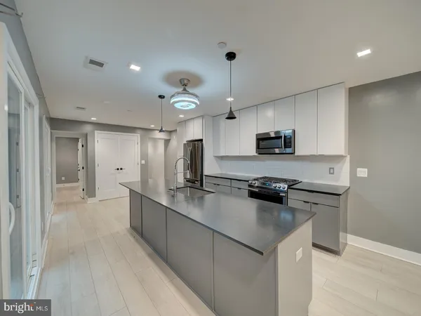 a kitchen with stainless steel appliances granite countertop a sink a stove and a refrigerator