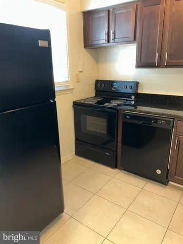 a kitchen with granite countertop a stove and a refrigerator