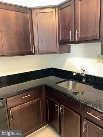 a kitchen with granite countertop a sink and cabinets
