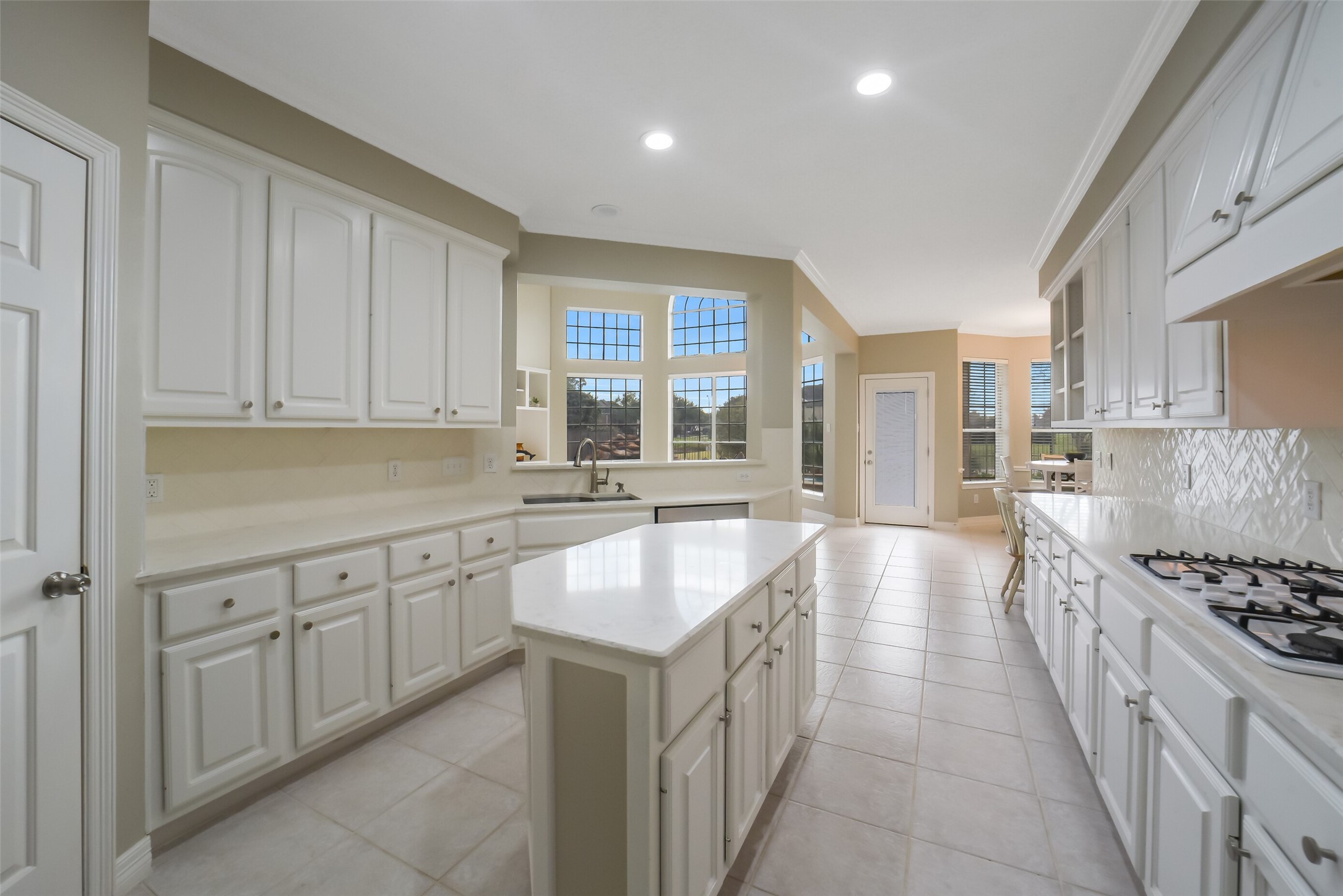 24403 Falcon Point Drive Katy, TX 77494 - Photo 10 of 32 Gourmet kitchen features quartz countertops, a spacious breakfast bar, custom cabinetry with plenty of storage space and a large center island.