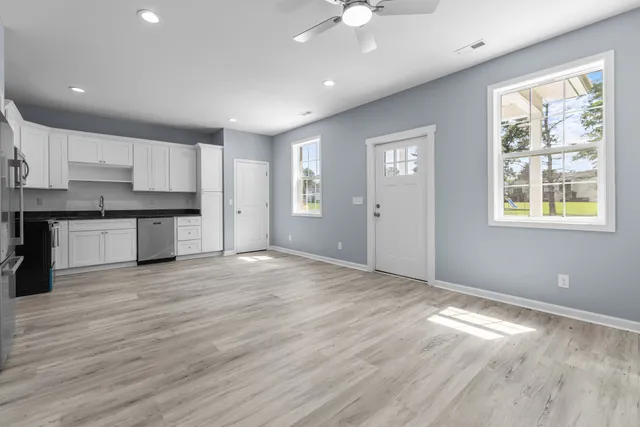 a view of a kitchen with a dishwasher cabinets and wooden floor