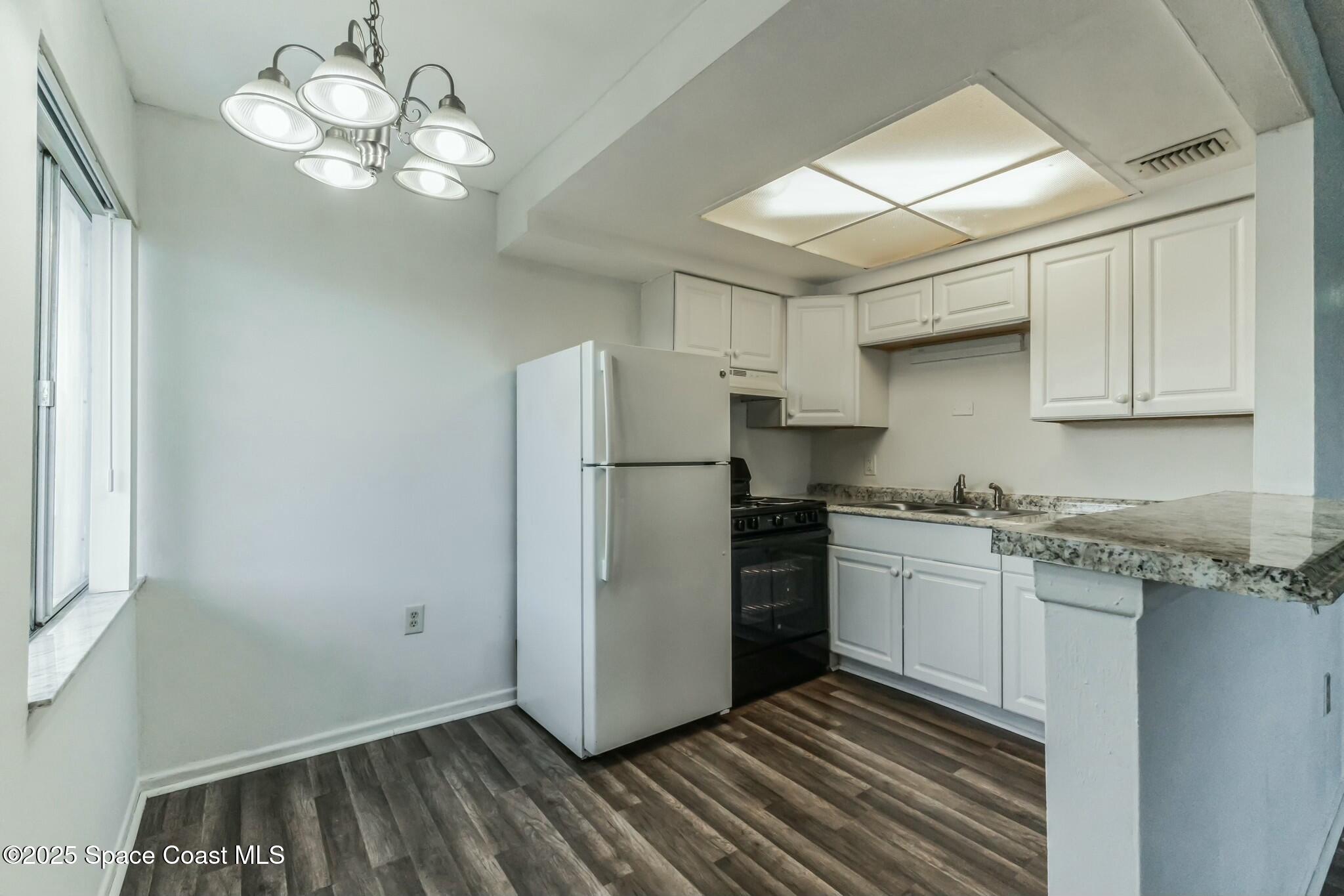 800 North Fiske Boulevard, Unit 513 Cocoa, FL 32922 - Photo 13 of 21 a kitchen with stainless steel appliances granite countertop a refrigerator a sink dishwasher a stove and white countertops with wooden floor