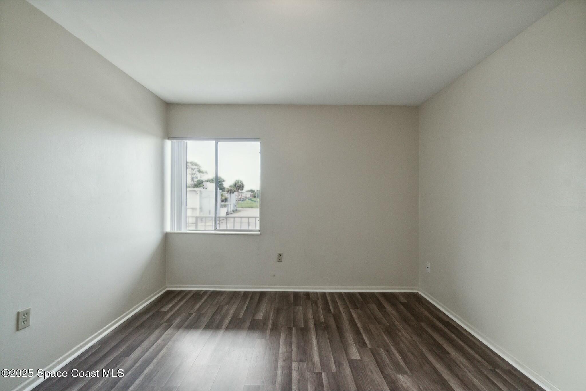 800 North Fiske Boulevard, Unit 513 Cocoa, FL 32922 - Photo 15 of 21 an empty room with wooden floor and windows
