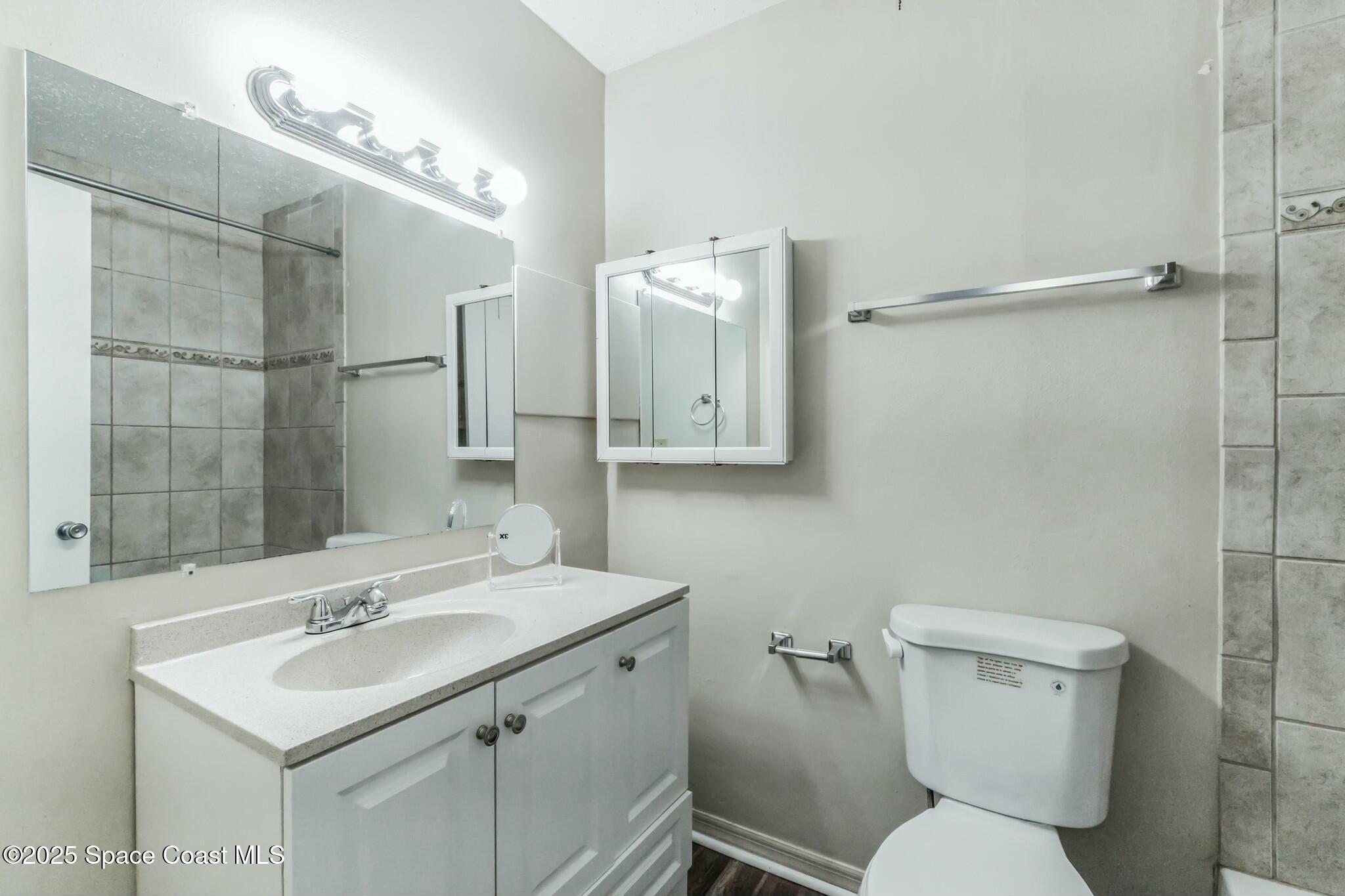 800 North Fiske Boulevard, Unit 513 Cocoa, FL 32922 - Photo 5 of 21 a bathroom with a sink toilet mirror and shower
