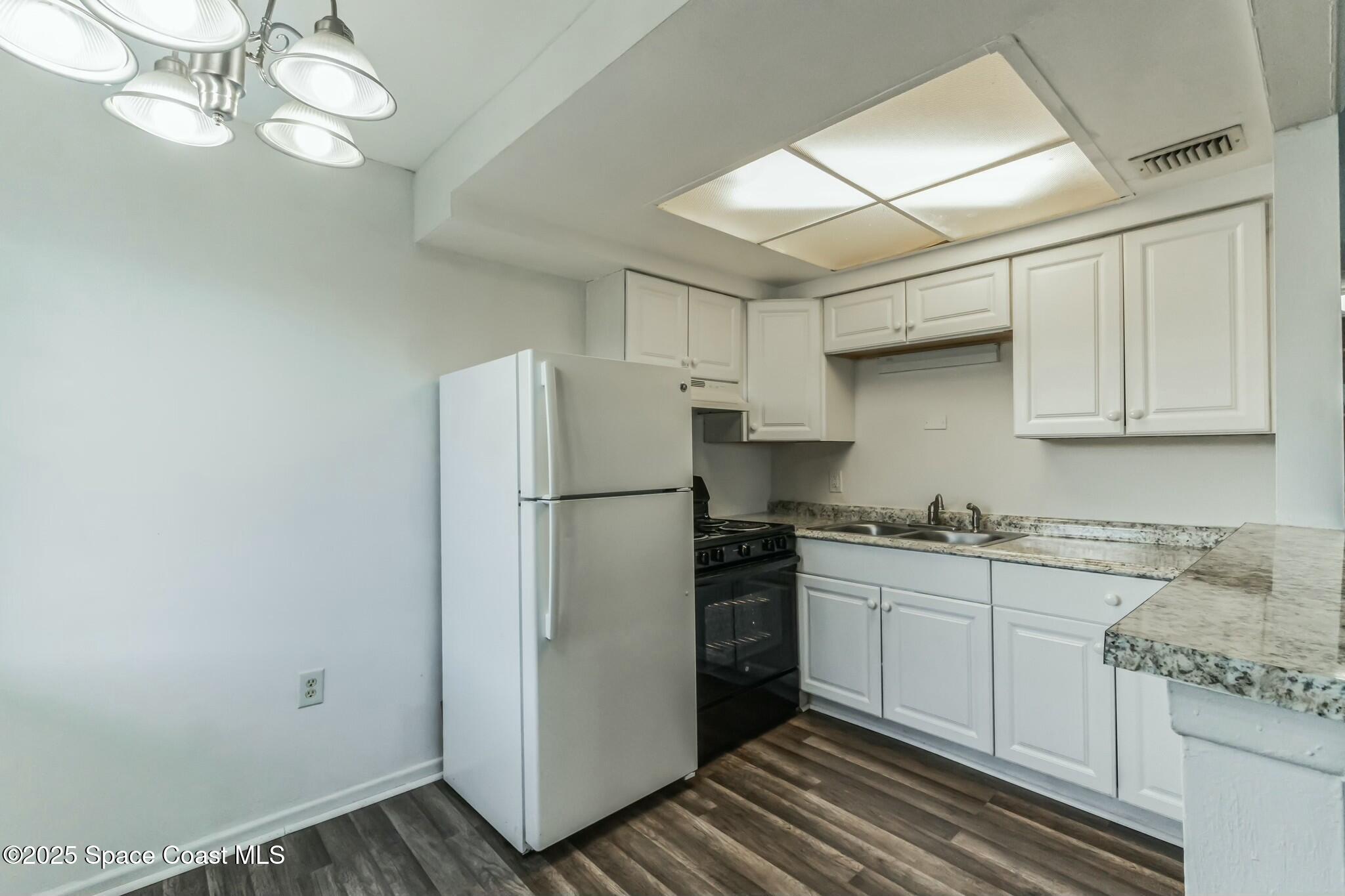 800 North Fiske Boulevard, Unit 513 Cocoa, FL 32922 - Photo 10 of 21 a kitchen with stainless steel appliances white cabinets and a refrigerator