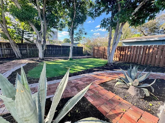 a view of backyard with outdoor seating and trees