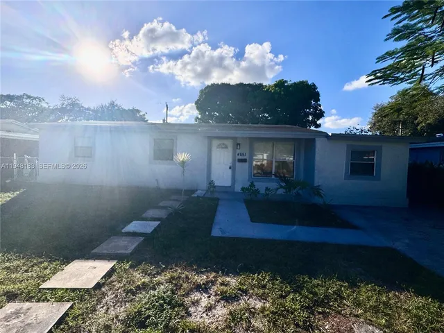 a front view of a house with garden and patio
