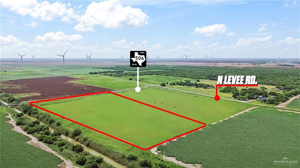 1/2 Farm To Market 506 Santa Rosa, TX 78593 - Photo 2 of 7 Green agricultural land bordered by a canal, with a distant road and scattered wind turbines