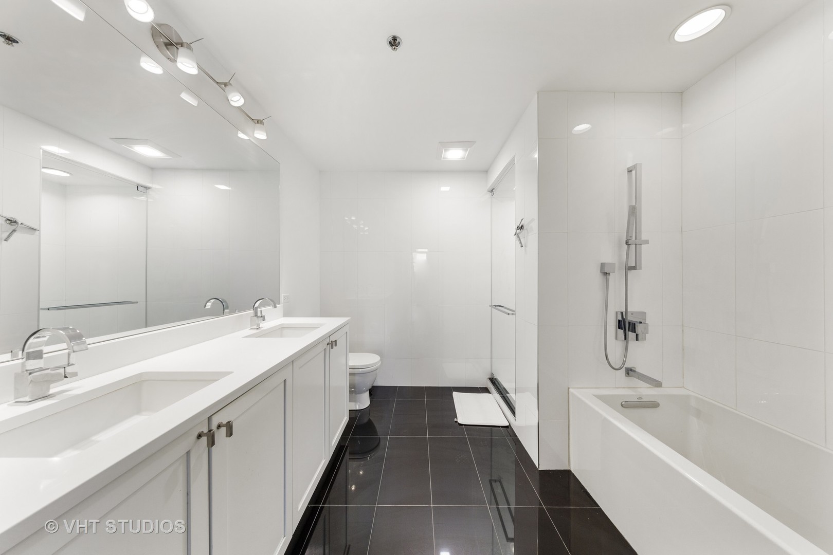 1255 South State Street, Unit 1603 Chicago, IL 60605 - Photo 14 of 21 a spacious bathroom with a double vanity sink a mirror and a bathtub