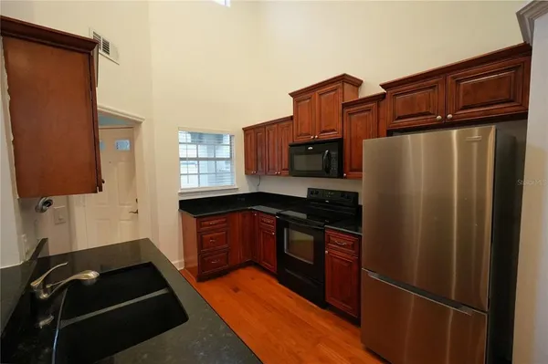 a kitchen with stainless steel appliances granite countertop a refrigerator and a sink