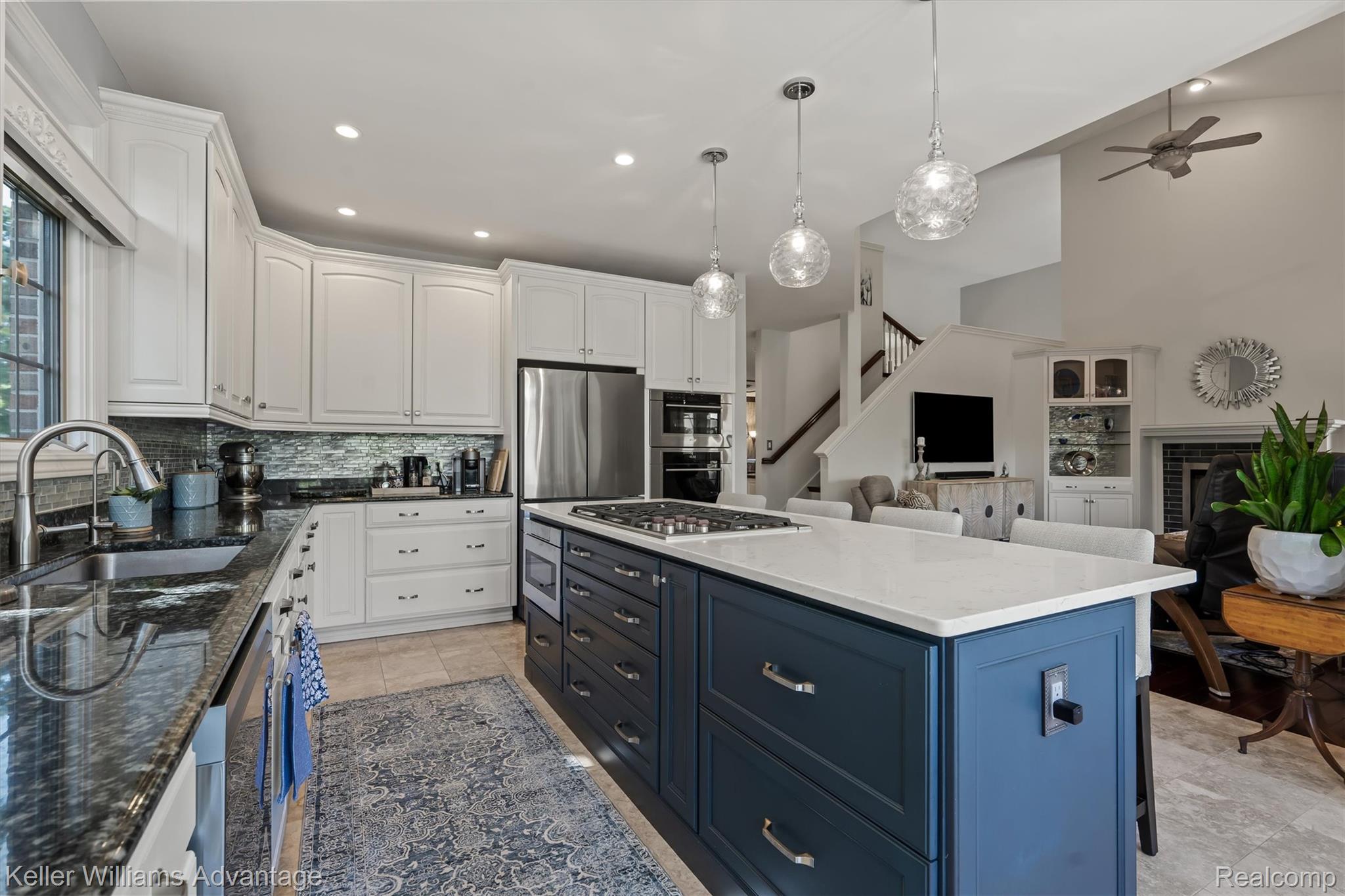 22878 Tree Top Court South Lyon, MI 48178 - Photo 9 of 75 Gourmet kitchen with two-tone cabinetry, stainless steel appliances, a center island with cooktop, and pendant lighting