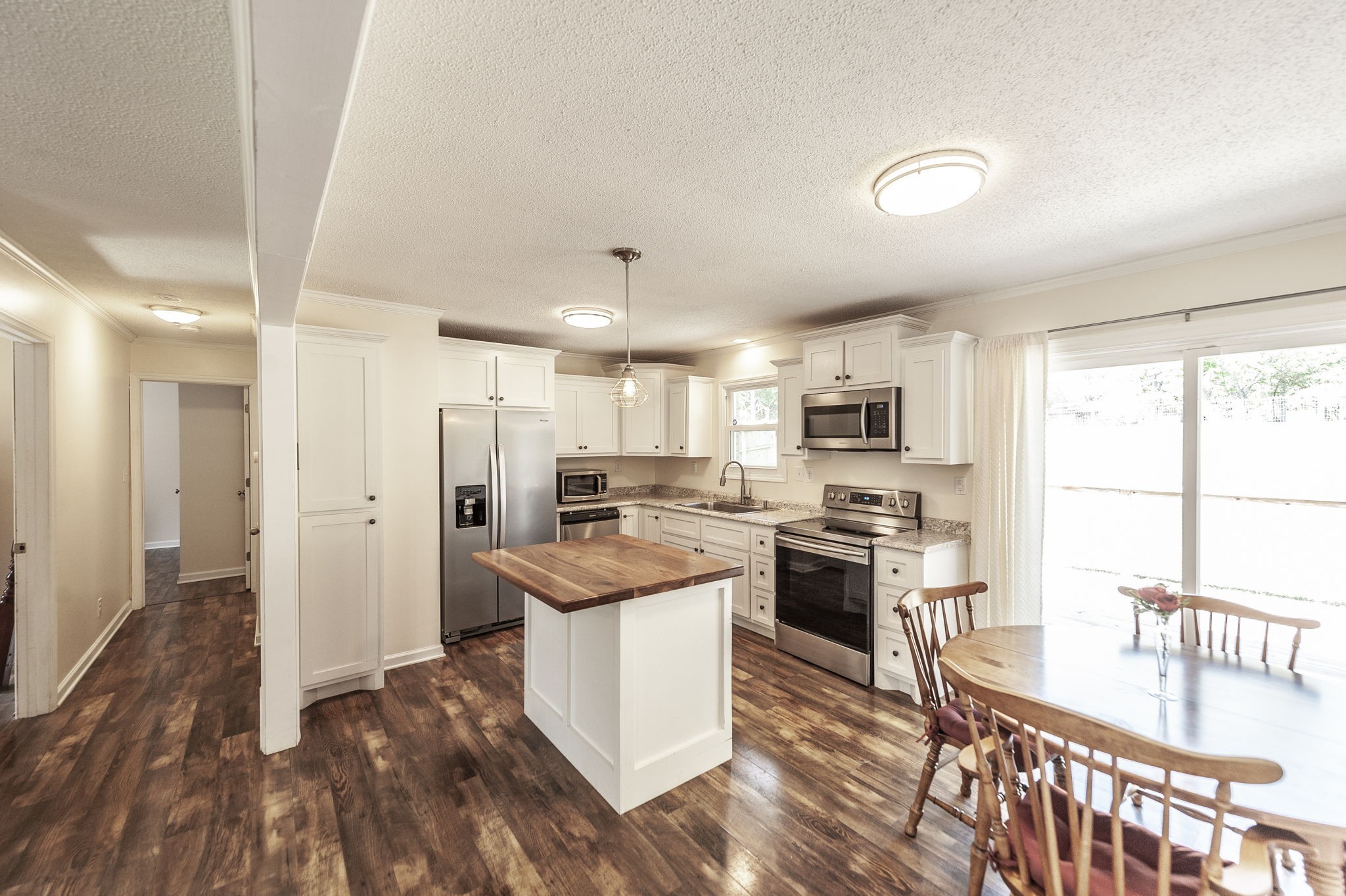 1711 Woodside Drive Springfield, TN 37172 - Photo 9 of 20 a kitchen with stainless steel appliances kitchen island granite countertop a stove top oven a sink a refrigerator white cabinets and wooden floor