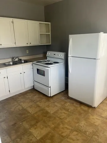 a kitchen with granite countertop cabinets stainless steel appliances and a counter space