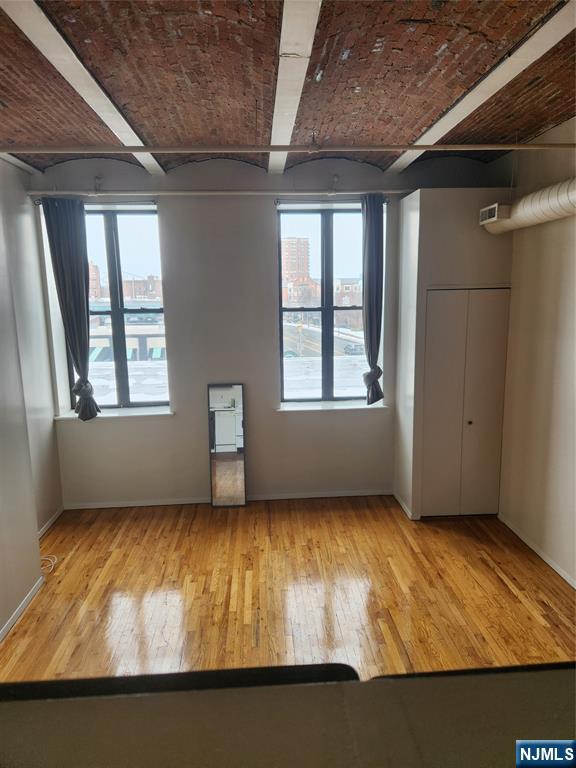 840 River Road, Unit 302 Edgewater, NJ 07020 - Photo 3 of 6 an empty room with wooden floor and windows