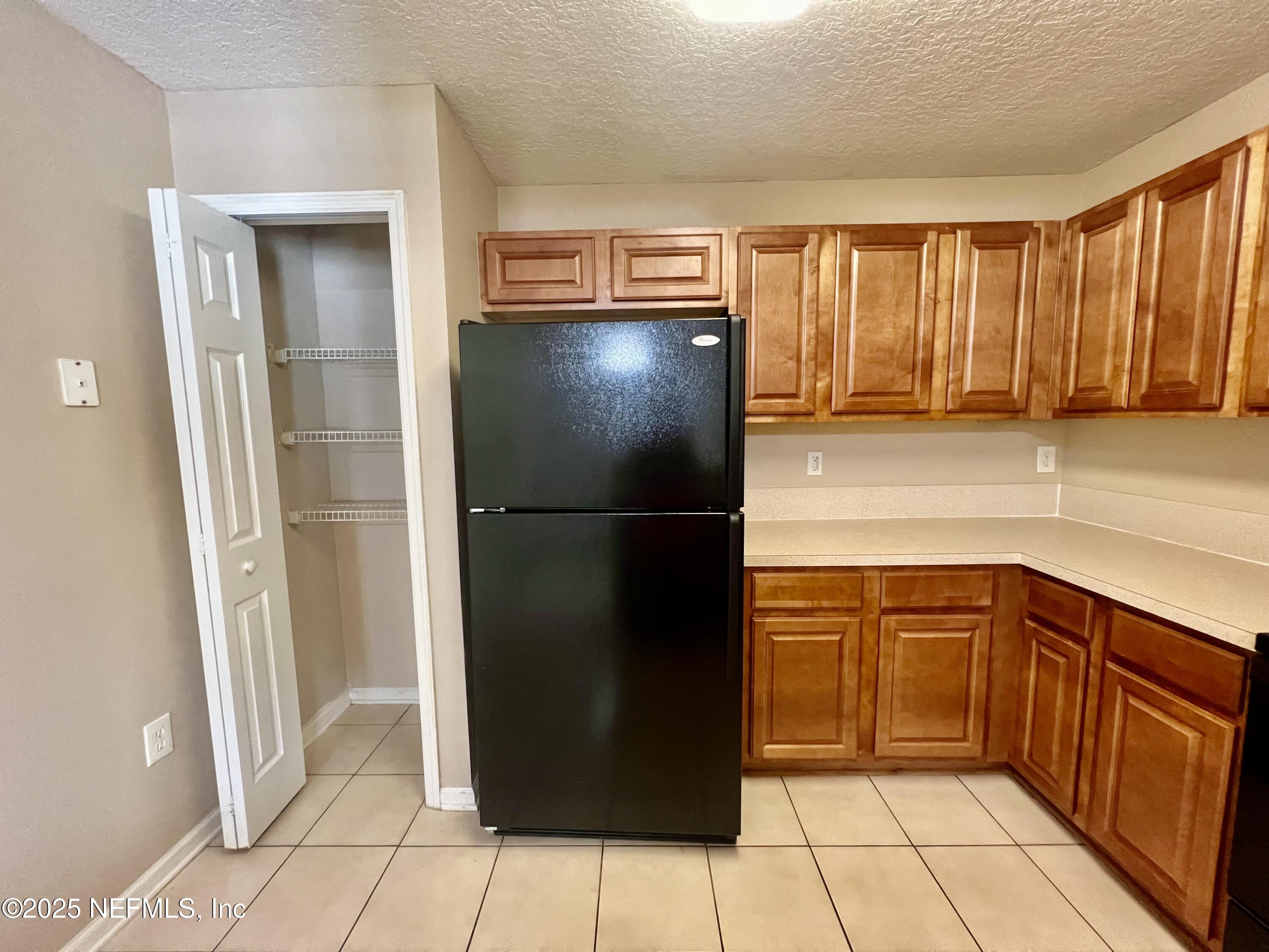 7920 Merrill Road, Unit 709 Jacksonville, FL 32277 - Photo 11 of 35 a kitchen with a refrigerator and a sink