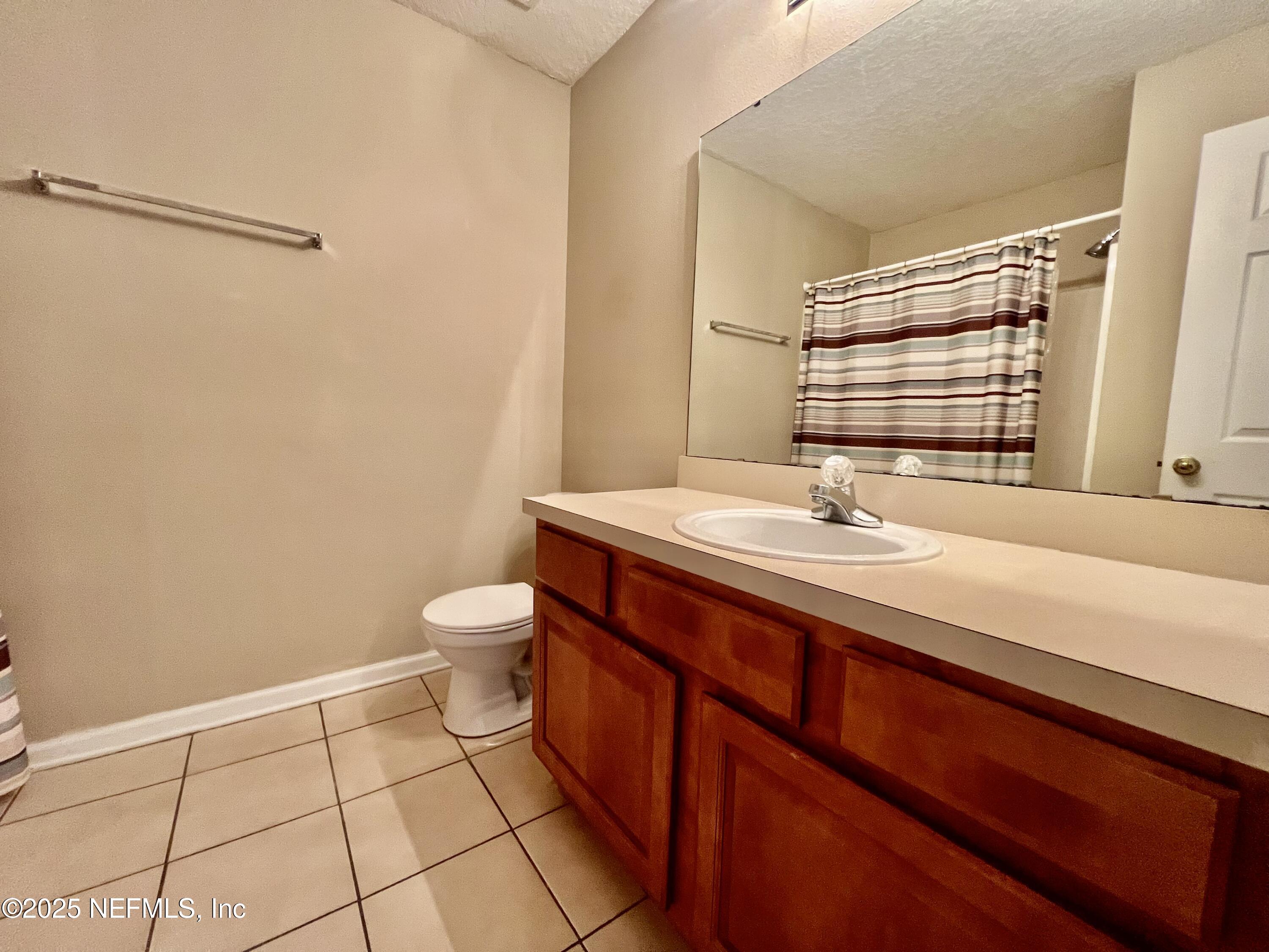 7920 Merrill Road, Unit 709 Jacksonville, FL 32277 - Photo 15 of 35 a bathroom with a sink a toilet and mirror