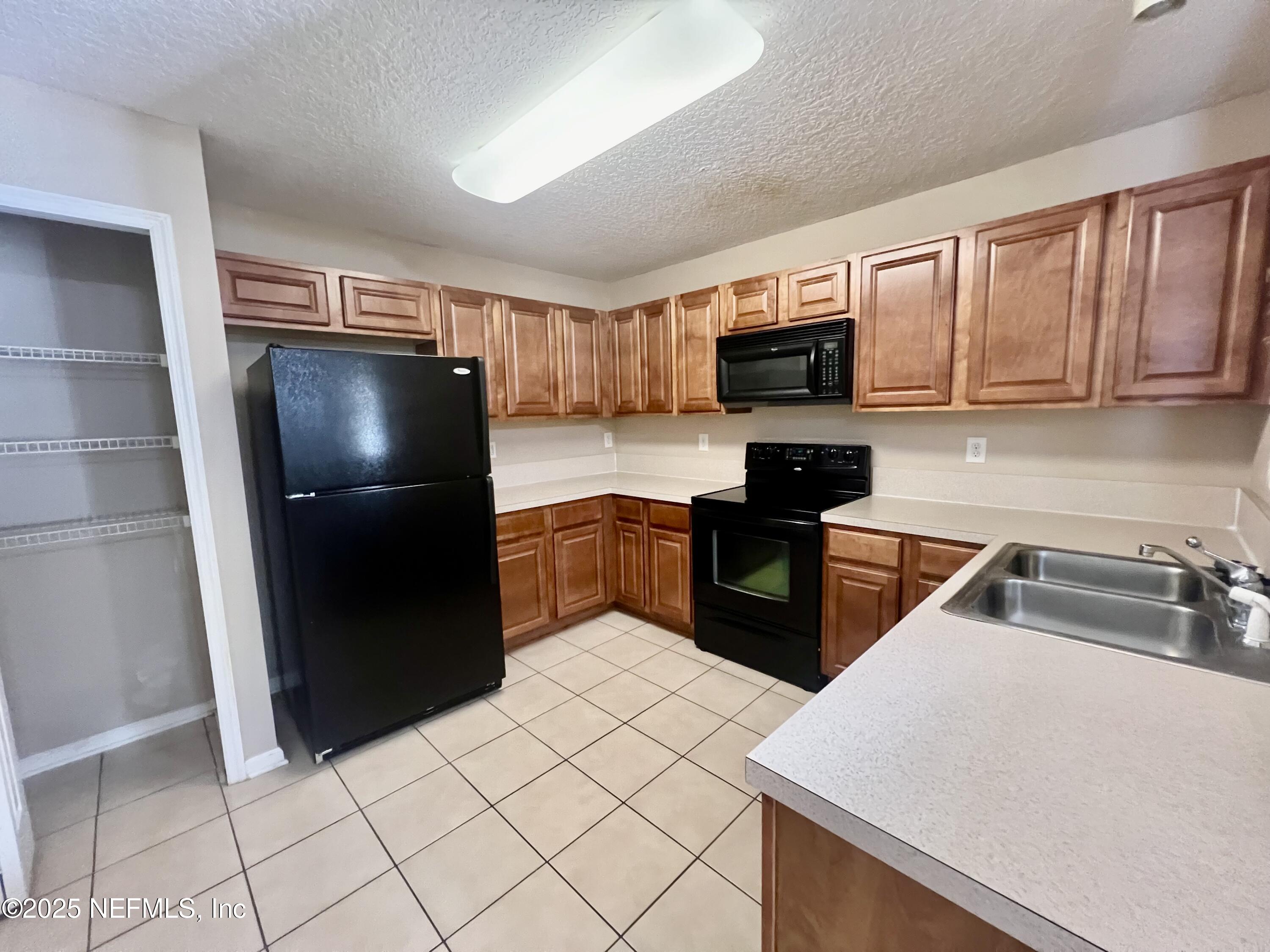 7920 Merrill Road, Unit 709 Jacksonville, FL 32277 - Photo 9 of 35 a kitchen with stainless steel appliances a refrigerator and a sink