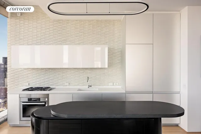 a kitchen with a sink a stove and white cabinets