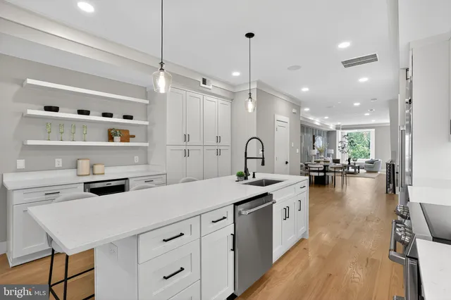 a kitchen with kitchen island granite countertop a sink stainless steel appliances and white cabinets