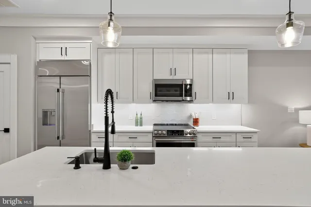 a kitchen with stainless steel appliances white cabinets and wooden floors