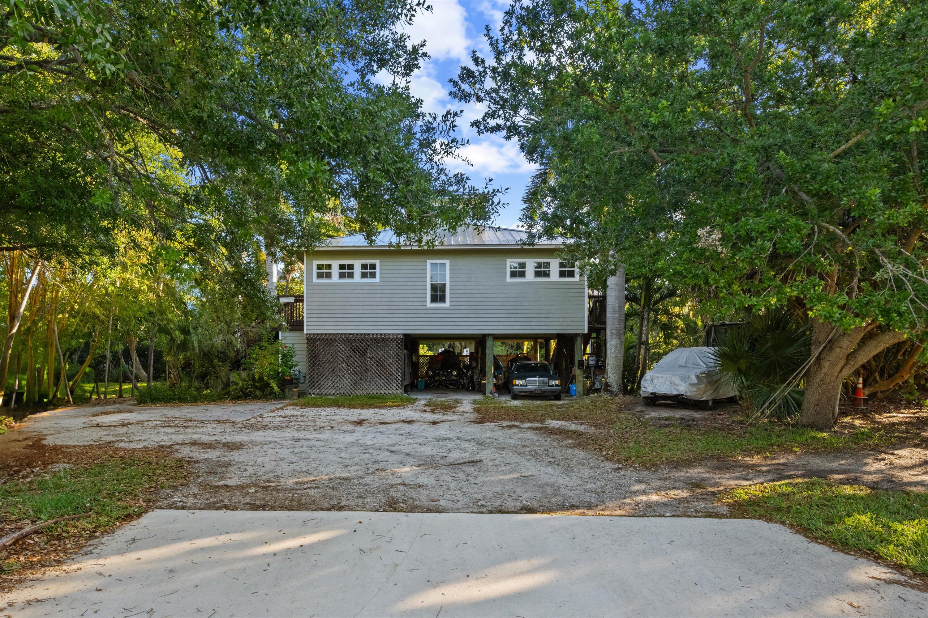 a view of a brick house next to a yard with large trees