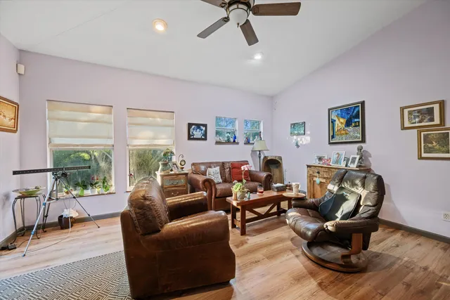 a sitting area with wooden floor and windows