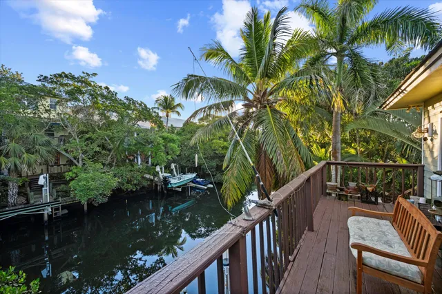 a backyard of a house with lawn chairs plants and lake view