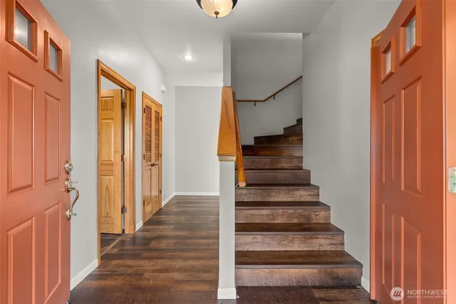 a view of an entryway with wooden floor and stairs