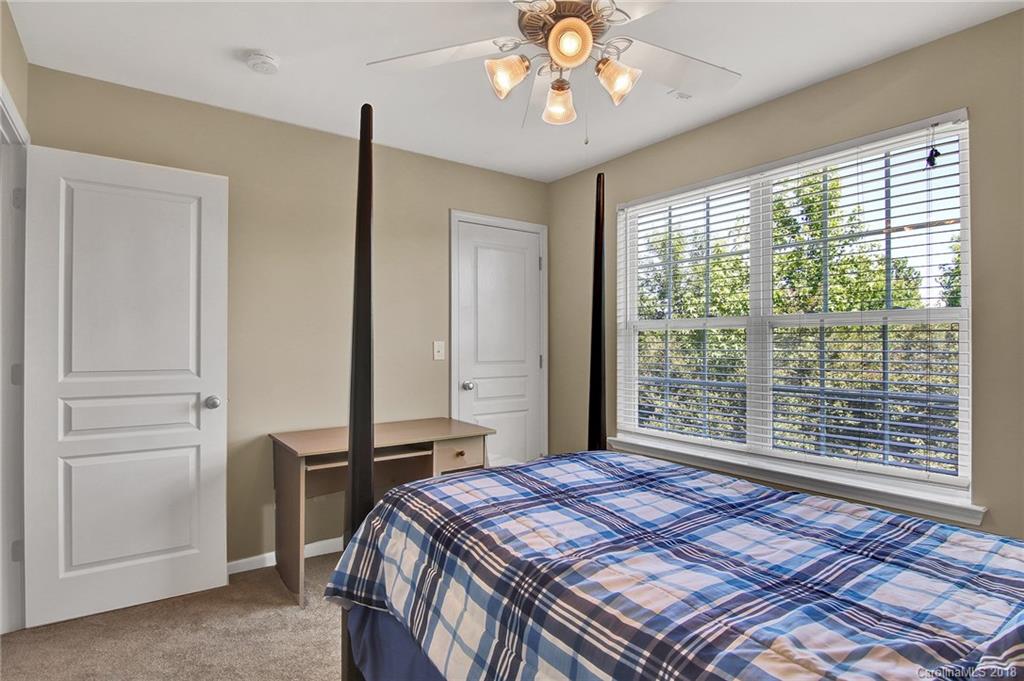 232 Dawn Mist Lane, Unit 40 Fort Mill, SC 29708 - Photo 18 of 28 a bedroom with a large bed and a chandelier
