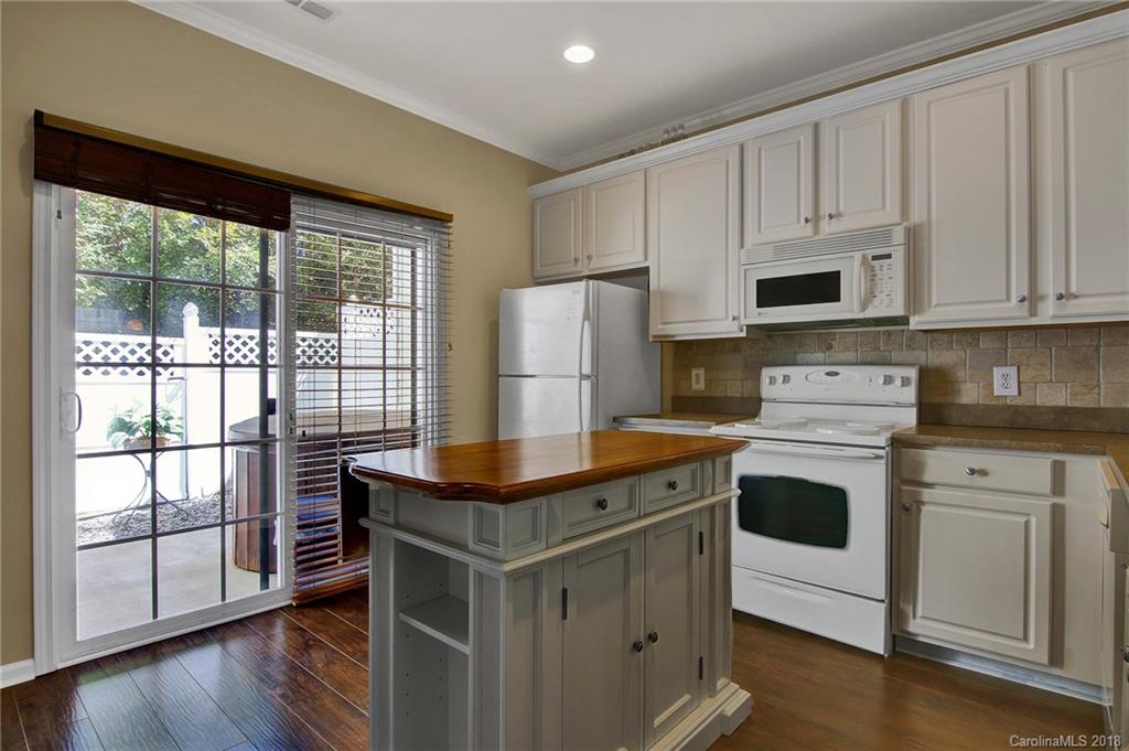 232 Dawn Mist Lane, Unit 40 Fort Mill, SC 29708 - Photo 9 of 28 a kitchen with stainless steel appliances granite countertop a stove a refrigerator a sink and white cabinets with wooden floor