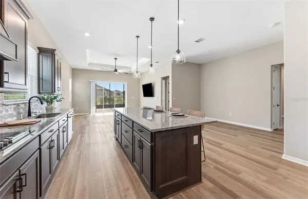 a kitchen with stainless steel appliances granite countertop a stove and a wooden floors