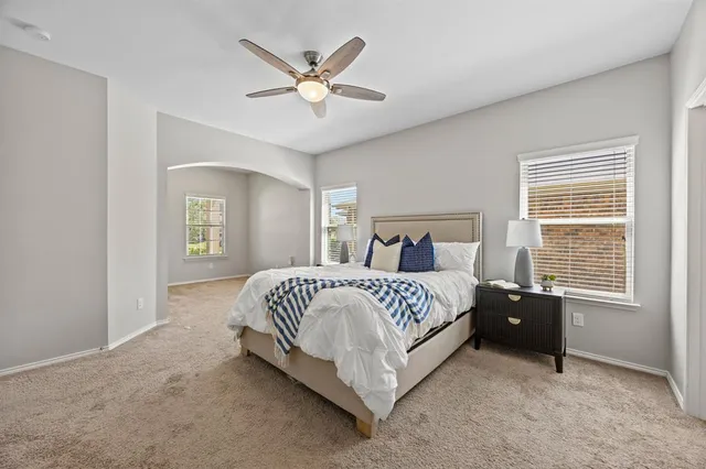 a spacious bedroom with a bed and a chandelier