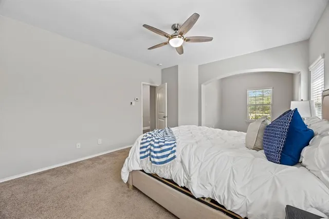 a bedroom with a large bed and a chandelier