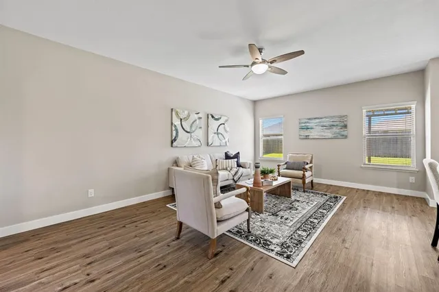 a living room with furniture and a wooden floor