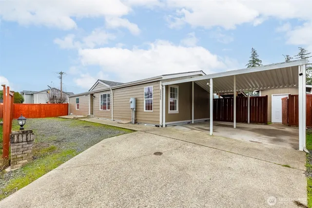 a front view of a house with a garden and yard