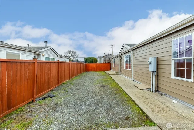 a view of a backyard with brick wall and wooden fence