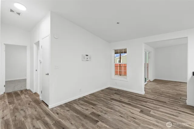 a view of an empty room with a fireplace and a window